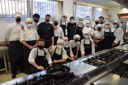 El xef Rafel Muria i un dels seus ajudants amb l'alumnat de segon de cuina de l'EHVO i el cap de cuina del centre.