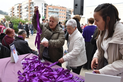 Membres del grup "Cosint oportunitats" han creat uns "lanyards" morats per a les persones que han assistit a l'acte.