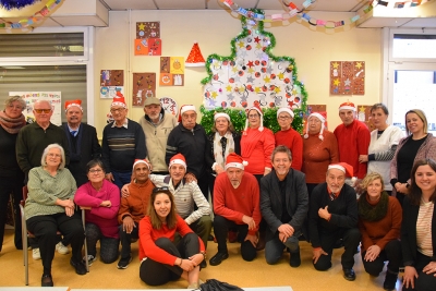 Foto de família de l'aperitiu de Nadal amb les persones usuàries del menjador social de la gent gran.