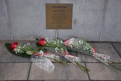 Detall de l'ofrena floral al davant de les plaques Stolpersteine.